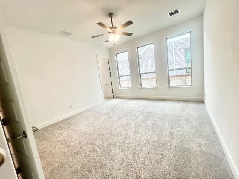 Carpeted spare room featuring baseboards and a ceiling fan Carpeted spare room featuring baseboards and a ceiling fan