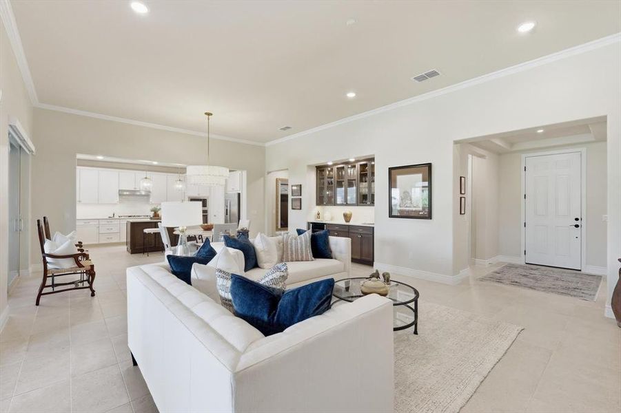 Living area featuring ornamental molding, recessed lighting, and light tile patterned floors