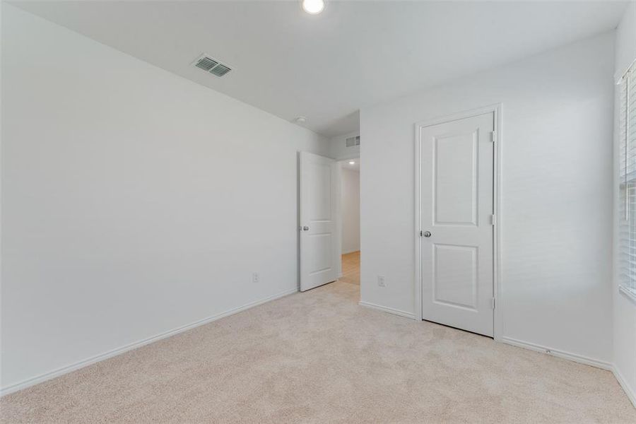 Unfurnished bedroom featuring light colored carpet