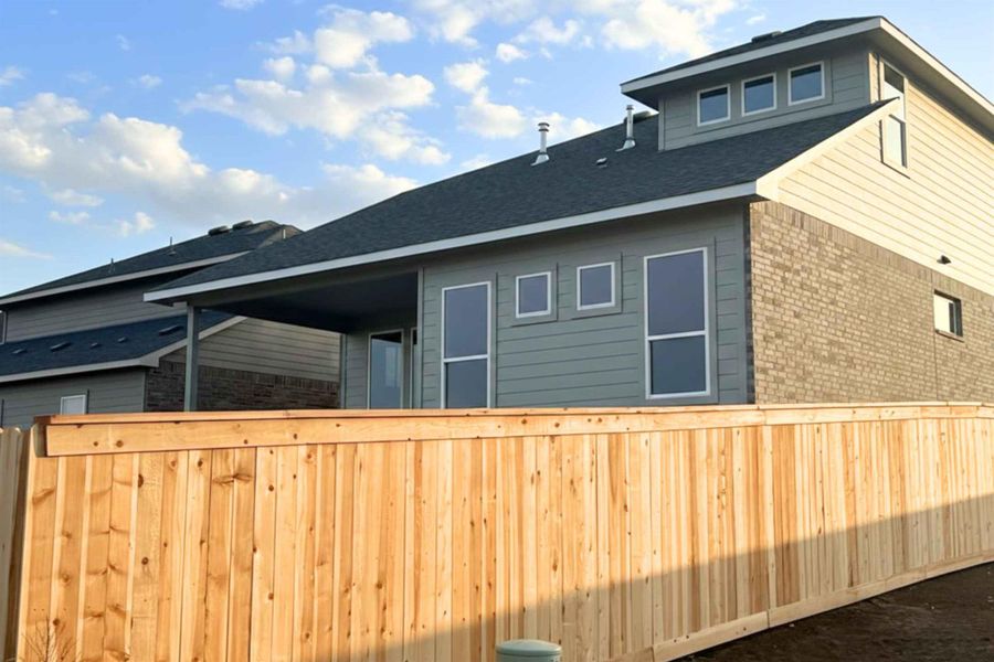 View of home's exterior with brick siding and roof with shingles