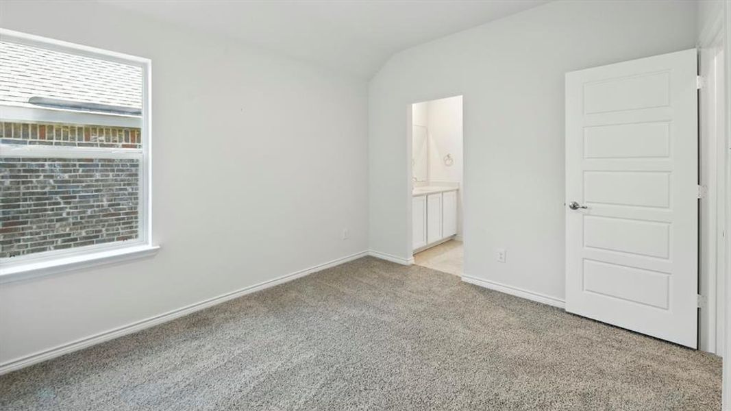 Unfurnished bedroom featuring carpet, vaulted ceiling, and ensuite bathroom Unfurnished bedroom featuring carpet, vaulted ceiling, and ensuite bathroom