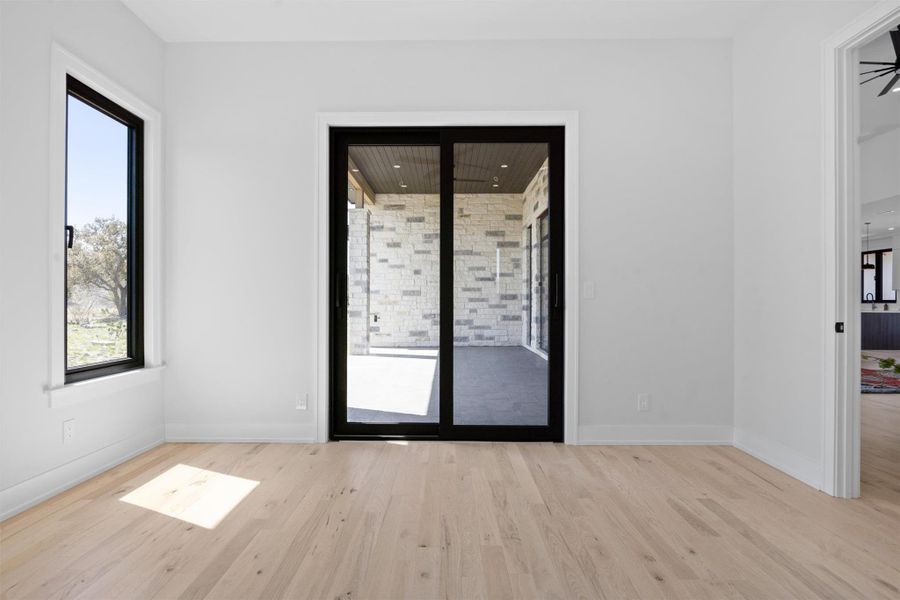 Room featuring baseboards and wood finished floors with a glass door leading to the backyard