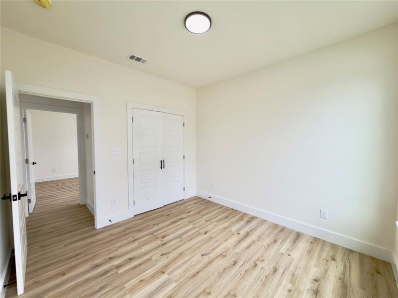 Room featuring wood-finish flooring, white walls, and a recessed ceiling light