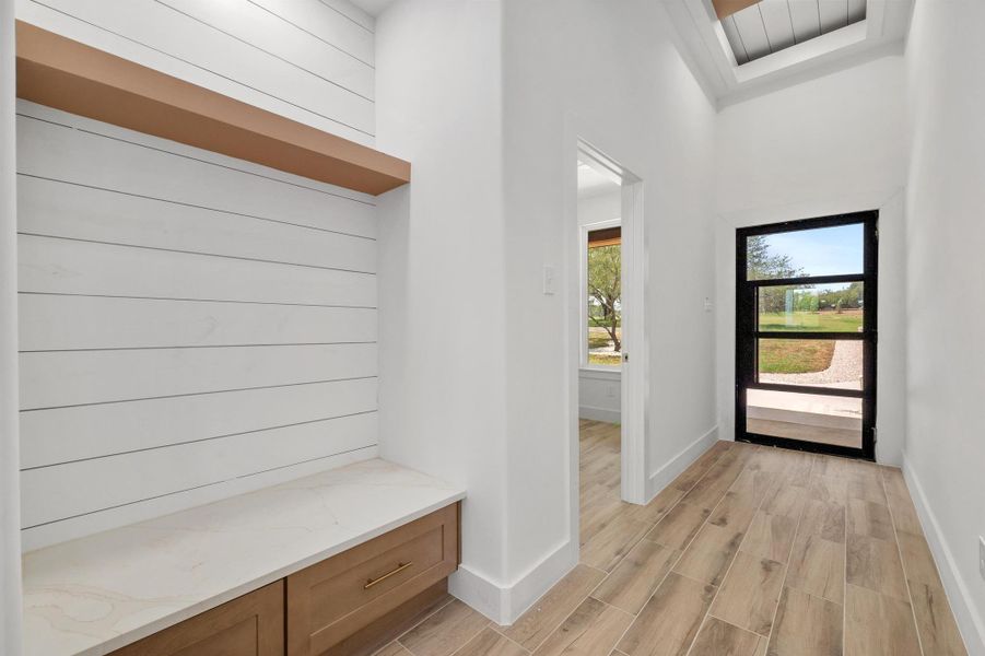 Mudroom with wood finish floors and a towering ceiling Mudroom with wood finish floors and a towering ceiling