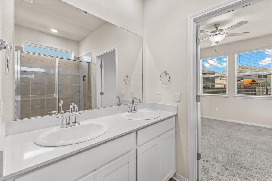 Bathroom featuring a stall shower and double vanity Bathroom featuring a stall shower and double vanity