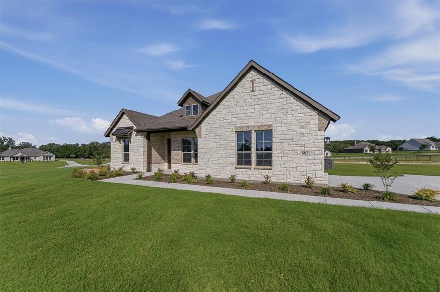 Stone and brick exterior featuring a multi-gabled roofline and dark framed windows Stone and brick exterior featuring a multi-gabled roofline and dark framed windows