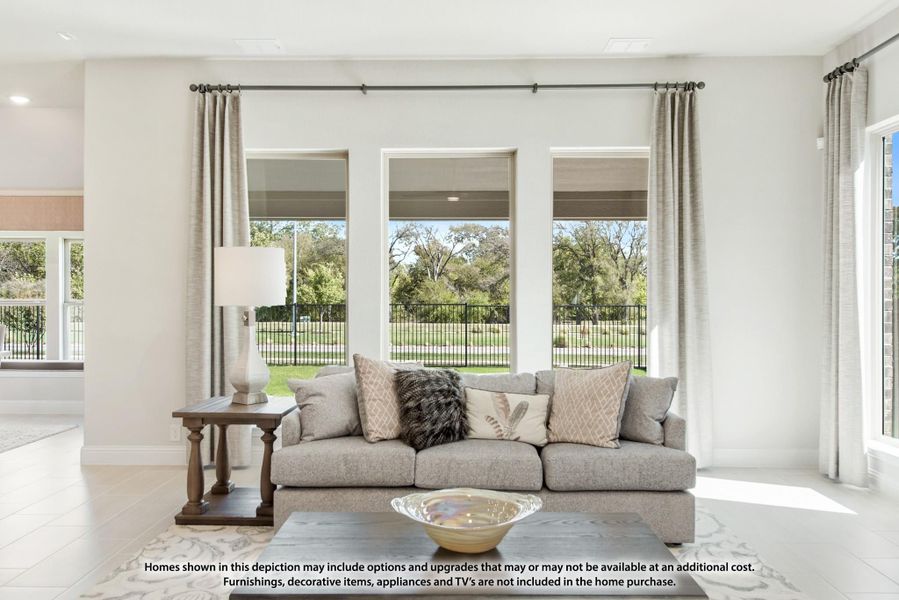 Bright living room with gray sofa, large windows, and backyard views Bright living room with gray sofa, large windows, and backyard views