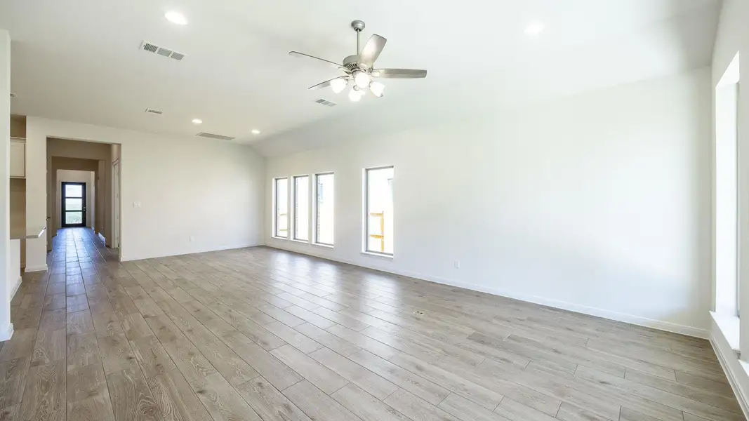 Spare room with recessed lighting, healthy amount of natural light, light wood-style flooring, vaulted ceiling, and a ceiling fan Spare room with recessed lighting, healthy amount of natural light, light wood-style flooring, vaulted ceiling, and a ceiling fan
