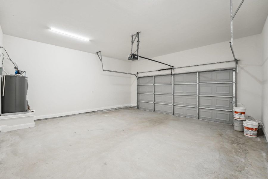 Garage featuring electric water heater and a garage door opener Garage featuring electric water heater and a garage door opener