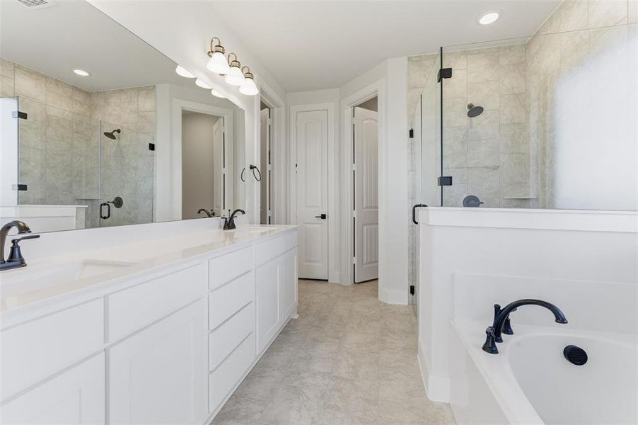 Full bathroom with double vanity, a bath, and a stall shower