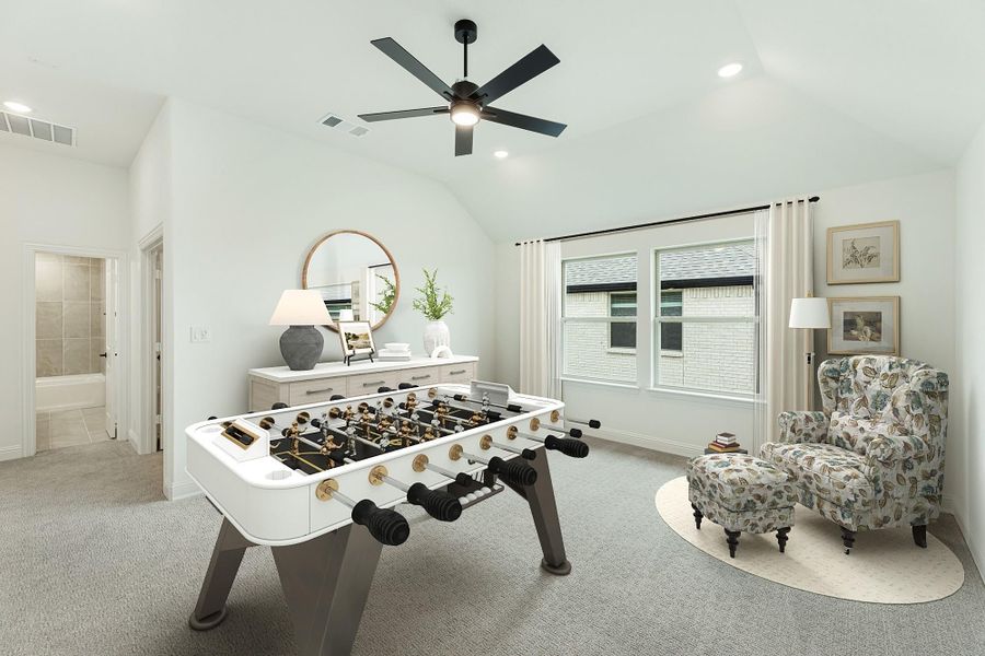 Game room with foosball table, vaulted ceiling, ceiling fan, and floral armchair on carpet