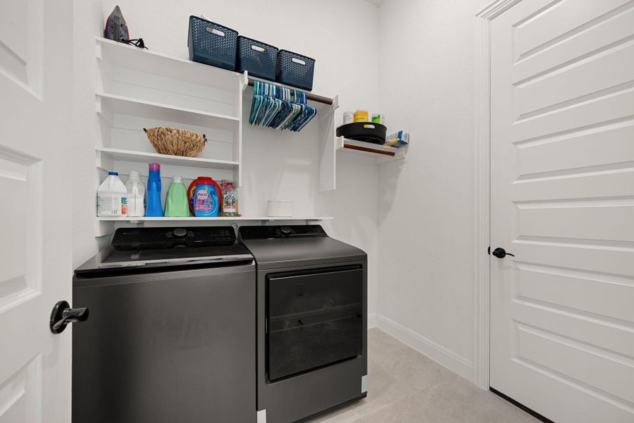 Functional laundry room offers built-in shelving and a convenient hanging rod for clothes. Functional laundry room offers built-in shelving and a convenient hanging rod for clothes.