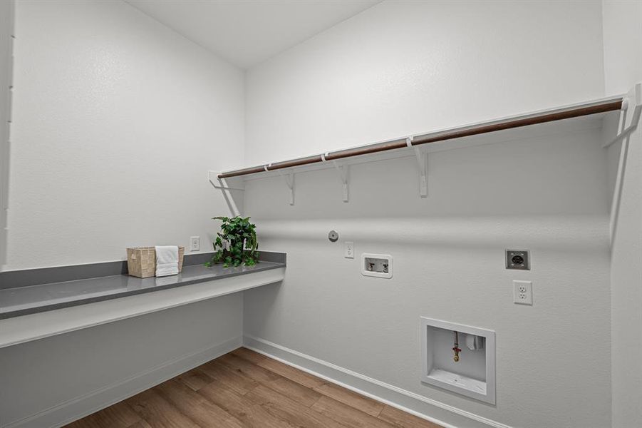 Utility room offers a folding table and is plumbed for a gas or electric dryer