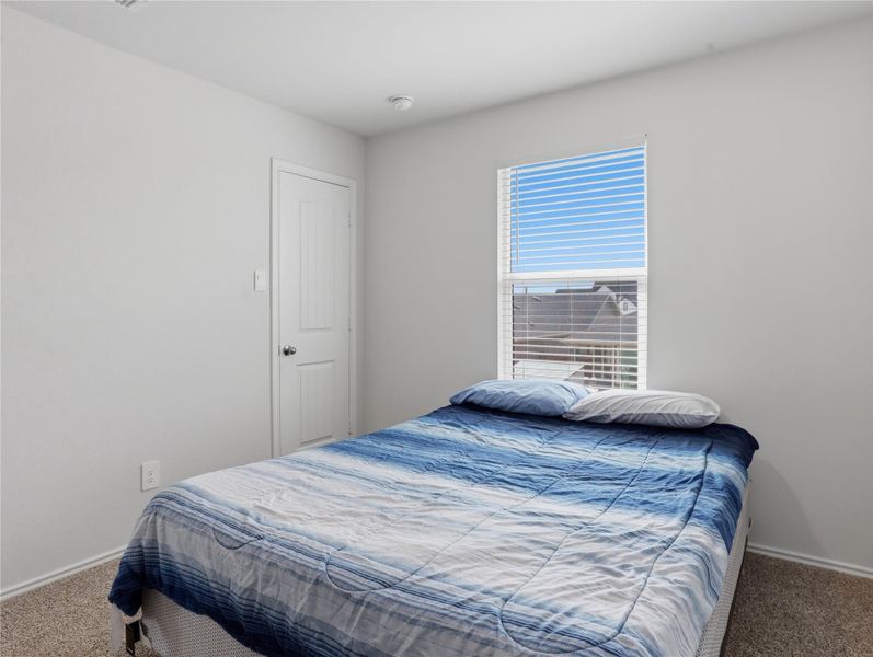 Plush carpeting and a large window define this comfortable bedroom space. Plush carpeting and a large window define this comfortable bedroom space.
