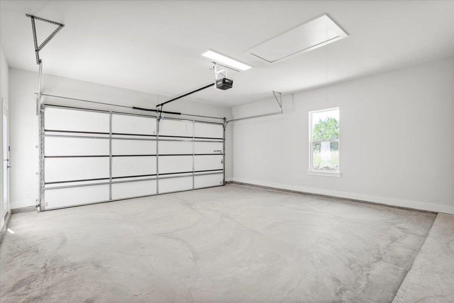 Garage with a garage door opener and baseboards Garage with a garage door opener and baseboards