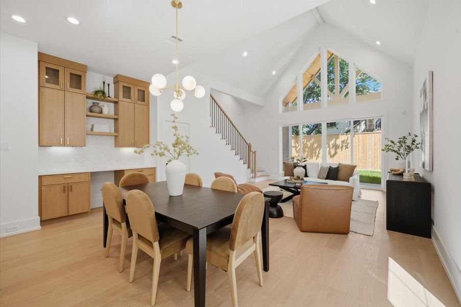 Soaring vaulted ceilings and expansive windows fill the open dining and living spaces with natural light and seamless connection to the outdoors.
