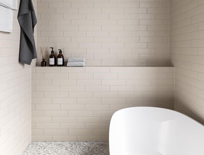 Elegant primary bathroom featuring sleek, neutral-toned tiles, a luxurious soaking tub, and stylish shelving for a spa-like retreat.