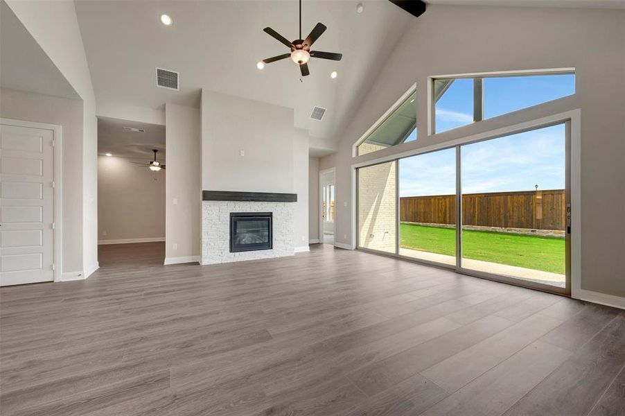 Spacious living area featuring a vaulted ceiling with exposed beams, an integrated ceiling fan, and recessed lighting