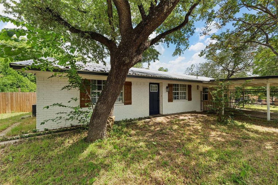 Ranch-style house with brick siding and metal roof Ranch-style house with brick siding and metal roof