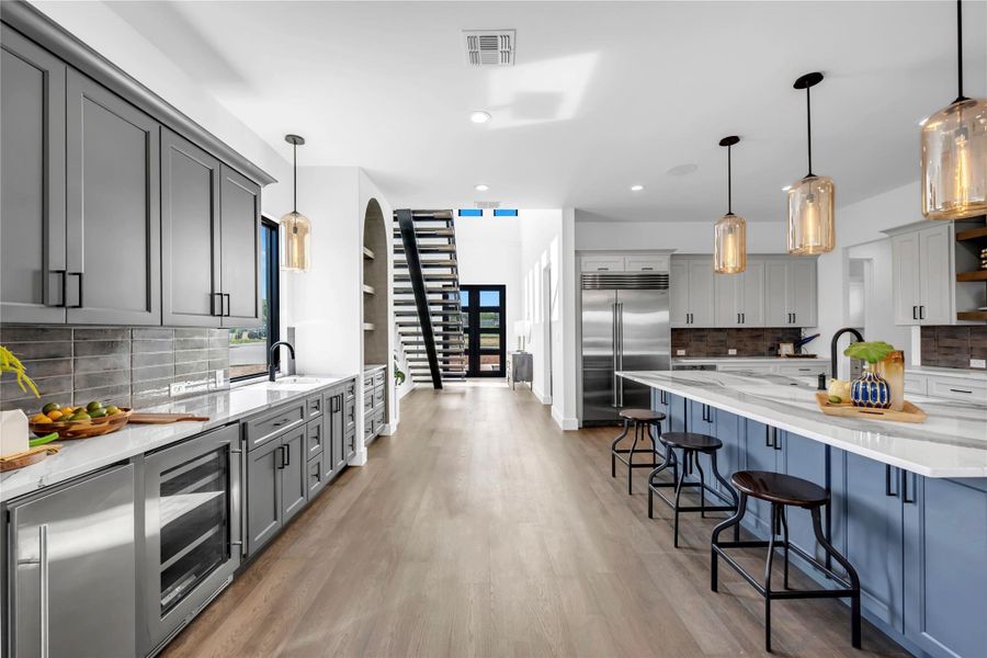 Kitchen featuring open shelves, gray cabinetry, decorative backsplash, light stone countertops, and recessed lighting