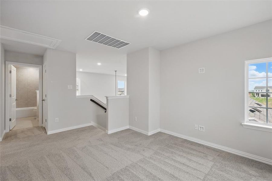 Unfurnished room with attic access, carpet flooring, and recessed lighting
