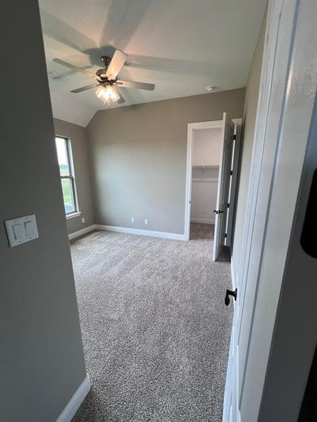 Carpeted spare room with lofted ceiling and ceiling fan