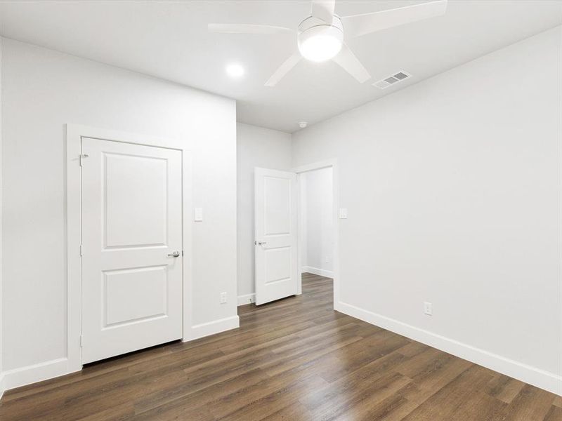 Unfurnished bedroom featuring ceiling fan and dark wood-style floors