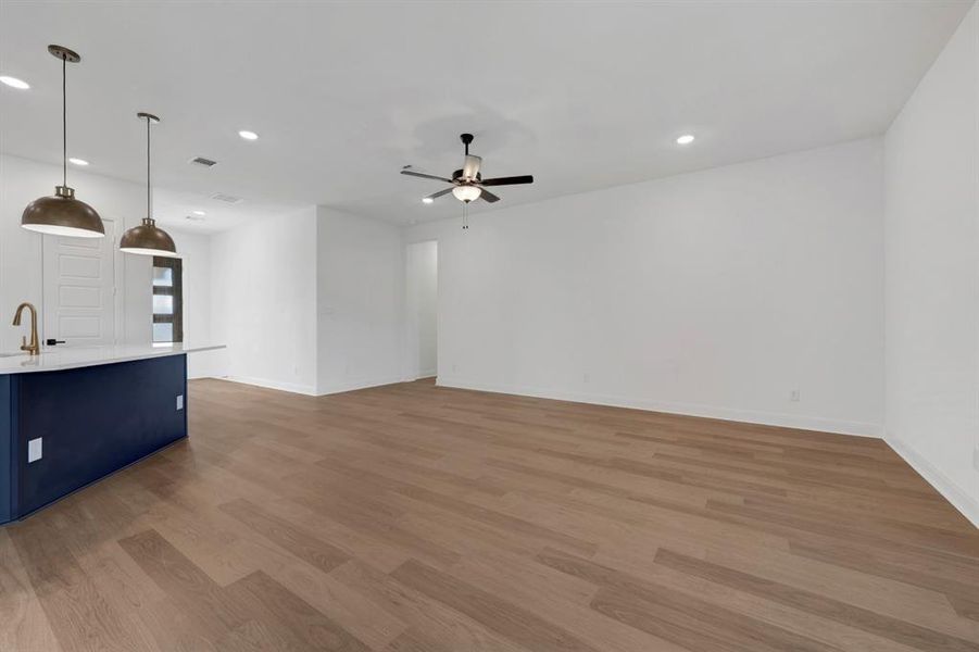 Unfurnished living room featuring a ceiling fan, dark wood-style flooring, and recessed lighting