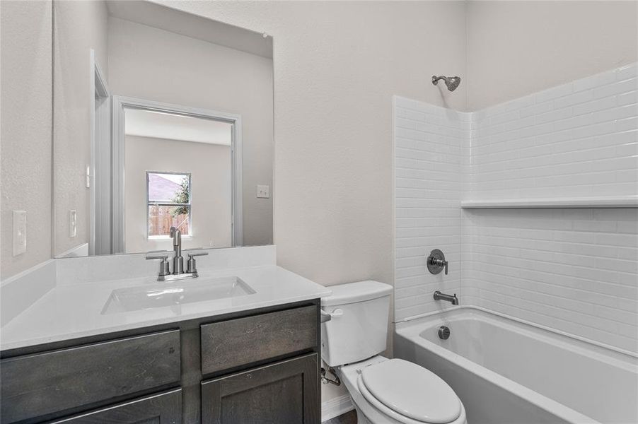 Full bath with shower combination, vanity, and a textured wall Full bath with shower combination, vanity, and a textured wall