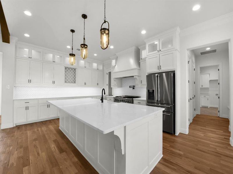 Kitchen with premium range hood, dark hardwood / wood-style flooring, white cabinets, and stainless steel appliances