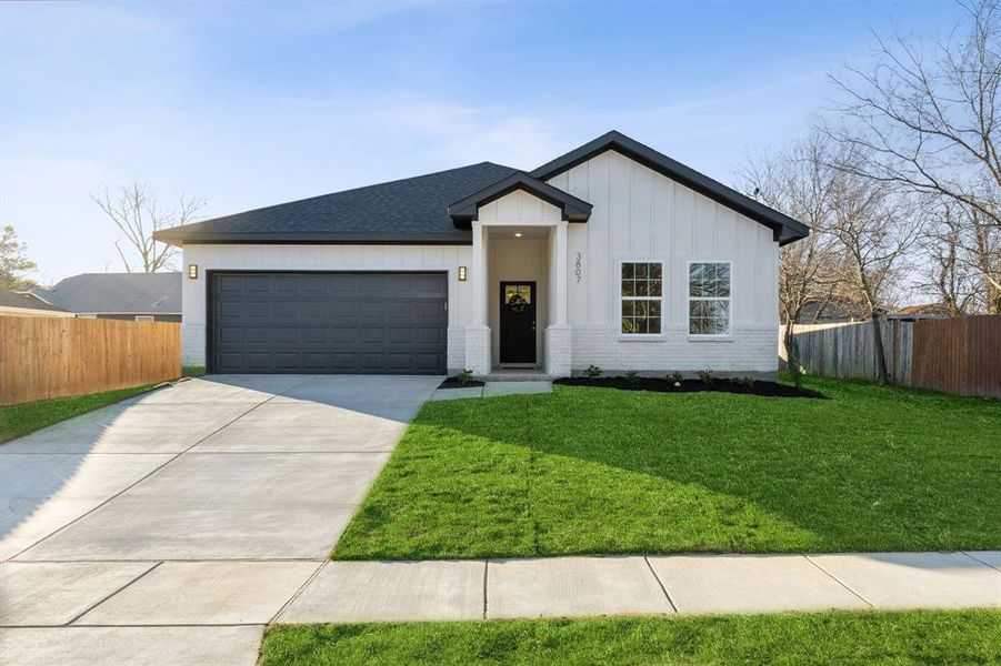 View of front of house featuring a front lawn and a 2 car garage