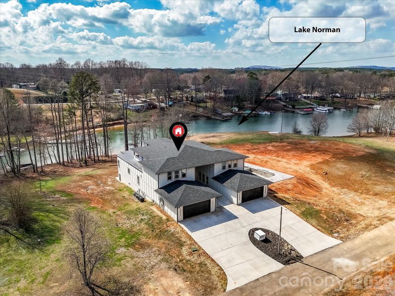 Aerial view of the property showcasing its prime location on a peaceful cove just off Lake Norman with expansive surrounding land.