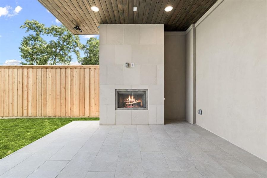 View of patio with a lit fireplace View of patio with a lit fireplace