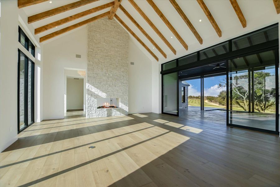 Unfurnished living room featuring a stone fireplace and hardwood / wood-style flooring