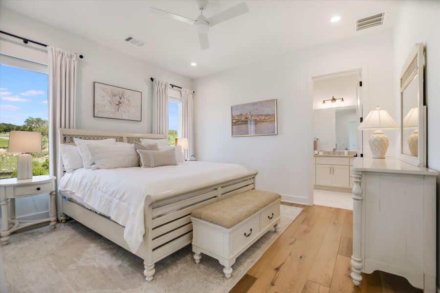 Bedroom with light wood-type flooring, recessed lighting, ensuite bathroom, a ceiling fan, and baseboards Bedroom with light wood-type flooring, recessed lighting, ensuite bathroom, a ceiling fan, and baseboards