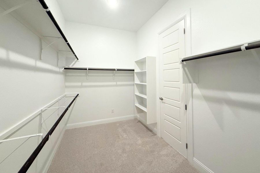Ample storage solutions abound in this spacious, well-appointed closet, featuring built-in shelving and hanging rods. Ample storage solutions abound in this spacious, well-appointed closet, featuring built-in shelving and hanging rods.