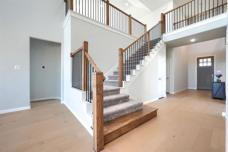 Staircase with wood finished floors and a towering ceiling Staircase with wood finished floors and a towering ceiling