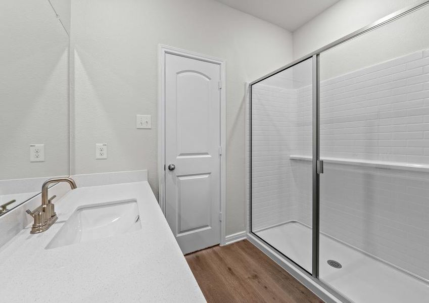 The master bathroom of the Piper has a large vanity space and glass, walk-in shower.