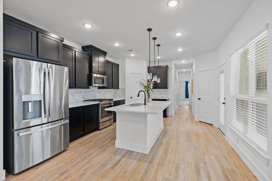 The spacious island kitchen is the heart of the home featuring a large center island, breakfast bar, lots of storage and plenty of workspace for cooking and entertaining.