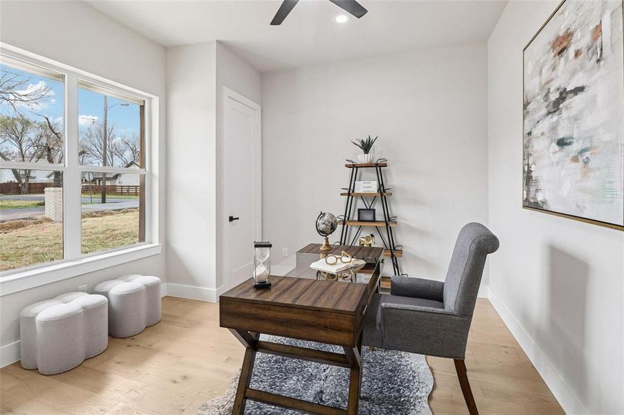 This bright interior features light-colored flooring, white walls, and a ceiling fan