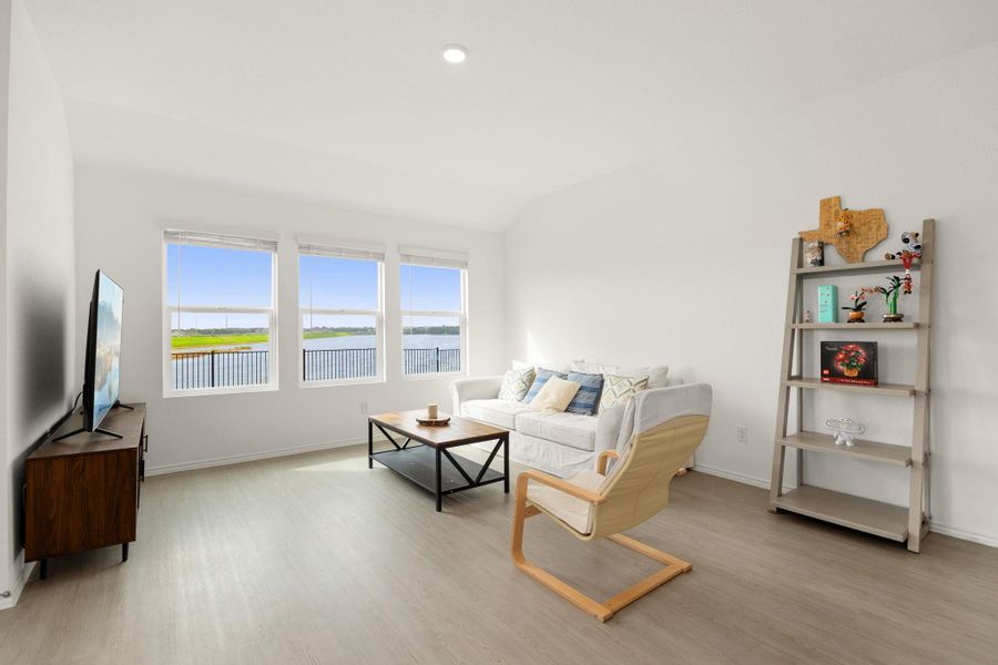 Bright windows frame a scenic lake view in this inviting living area.