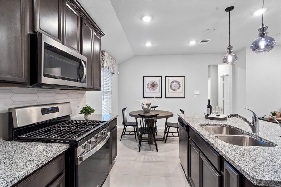 The U-shaped kitchen opens directly into a cozy dining area, perfectly blending cooking and eating spaces while maintaining a modern, connected feel.