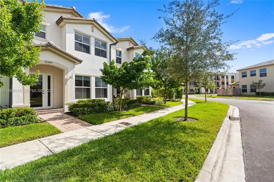 Front exterior of a new home in Harmony Parc, Homestead, FL, highlighting curb appeal (Image 1).