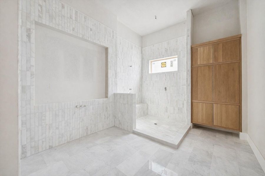 An elegant walk in shower featuring vertically set marble tile and a clean, timeless aesthetic. The soft natural light from the window enhances the texture and detail of the stone, creating a bright and tranquil environment. Designed with simplicity and longevity in mind, this shower is both luxurious and enduring. An elegant walk in shower featuring vertically set marble tile and a clean, timeless aesthetic. The soft natural light from the window enhances the texture and detail of the stone, creating a bright and tranquil environment. Designed with simplicity and longevity in mind, this shower is both luxurious and enduring.