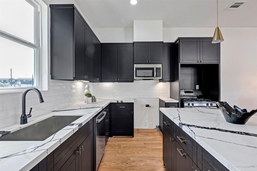 Another close-up view of the kitchen, highlighting the efficient layout of the appliances and the details of the cabinetry for a polished, functional space. (Representation of previously built homes. Actual colors and finishes will vary.) Another close-up view of the kitchen, highlighting the efficient layout of the appliances and the details of the cabinetry for a polished, functional space. (Representation of previously built homes. Actual colors and finishes will vary.)