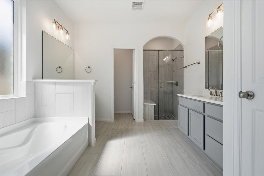 Full bathroom featuring vanity, a stall shower, and a bath