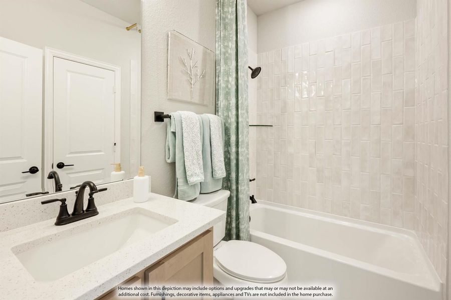 Full bathroom with quartz vanity, white tile tub-shower combo, and dark matte fixtures