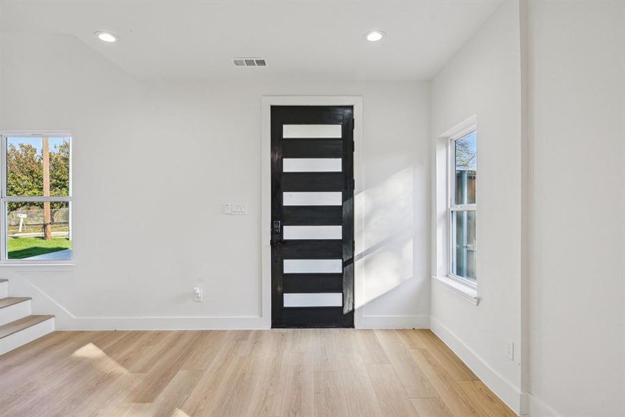 Foyer entrance with light wood-type flooring, recessed lighting, stairs, and healthy amount of natural light