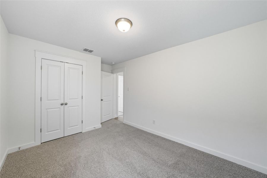 Unfurnished bedroom featuring carpet and a closet