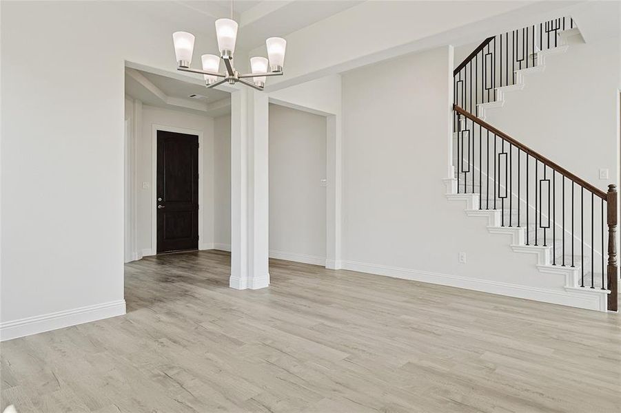 Unfurnished dining area with a chandelier and light hardwood / wood-style floors